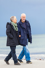 Image showing happy elderly senior couple walking on beach