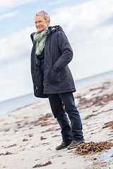 Image showing happy elderly senior couple walking on beach