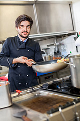 Image showing Chef cooking a vegetables stir fry over a hob