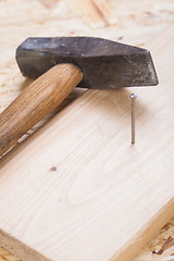 Image showing Mallet with nails and planks of new wood