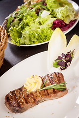 Image showing Grilled beef steak topped with butter and rosemary