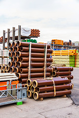 Image showing Several pipes stacked in yard