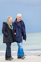 Image showing happy elderly senior couple walking on beach