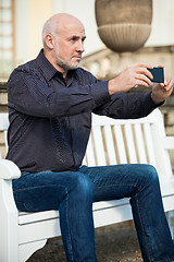 Image showing Man taking a photograph with his mobile