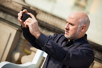 Image showing Man taking a photograph with his mobile