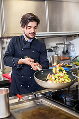 Image showing Chef cooking a vegetables stir fry over a hob