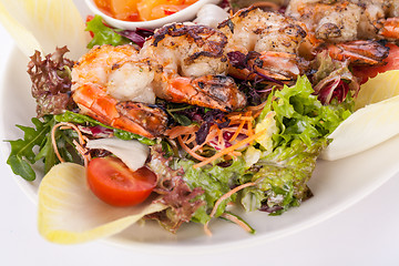 Image showing Grilled prawns with endive salad and jacket potato