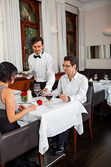 Image showing Waiter happily accommodating couple