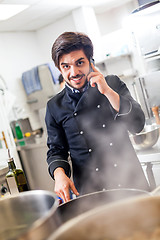 Image showing Chef taking a call on his smartphone