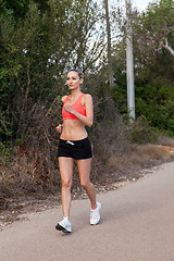 Image showing Fit young woman jogging