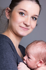 Image showing Young mother carrying infant