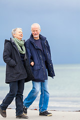 Image showing happy elderly senior couple walking on beach