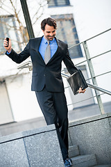 Image showing Smiling businessman walking down stairs