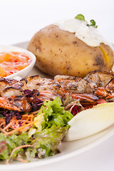 Image showing Grilled prawns with endive salad and jacket potato