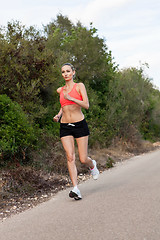 Image showing Fit young woman jogging