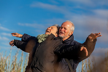 Image showing Elderly couple embracing and celebrating the sun