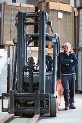 Image showing Posing alongside a forklift