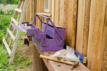 Image showing purple toolbox hammer nail on wooden table outdoor 