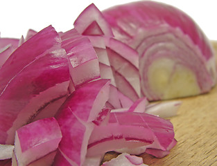 Image showing Diced red onion on a brown wooden plate