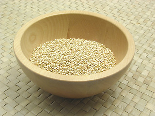 Image showing Wooden bowl with quinoa on rattan underlay