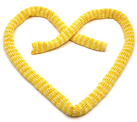 Image showing Yellow striped knitting scarf arranged as heart on white