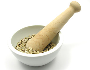 Image showing Pestling sunflower seeds in a bowl of chinaware