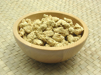 Image showing Wooden bowl with soy granules on rattan underlay