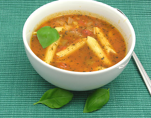 Image showing Noodle soup with tomatoes and herbs on green
