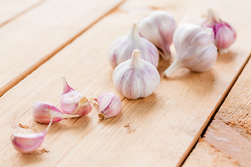 Image showing raw garlic on a wooden plank