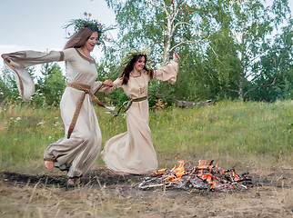 Image showing Attractive women jumping through fire