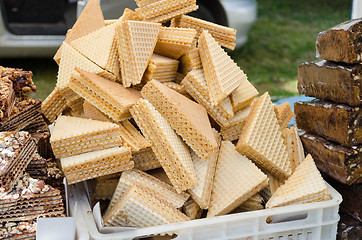 Image showing layered vanilla wafer pile on stall outdoor market 
