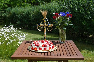 Image showing Homemade strawberry cake on decorated table in garden