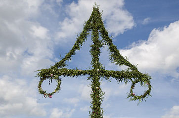 Image showing Top of a midsummer pole at sky with white clouds