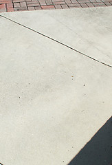 Image showing cement sidewalk with brick and shadow