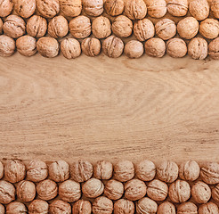 Image showing Unshelled Walnuts Lying On Desk