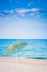 Image showing White striped umbrella on beach