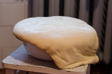 Image showing yeast dough rise through metal edges of the bowl 