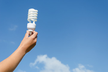 Image showing hand hold energy saving lamp blue sky background 