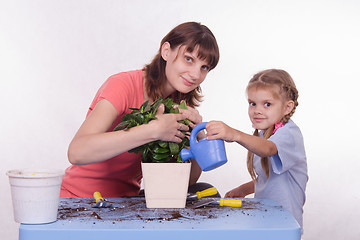 Image showing Mom and daughter watering flower