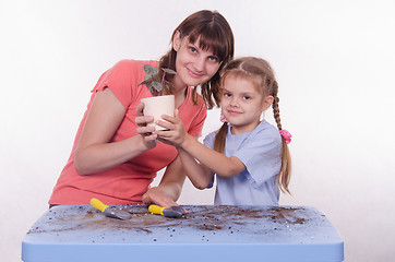 Image showing Mom and daughter planted flower room in the pot