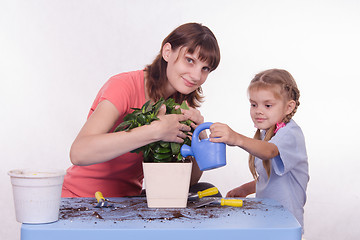 Image showing Mom and daughter watering flower pot