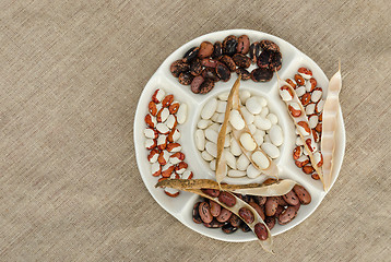 Image showing colorful bean in plate on linen texture background 