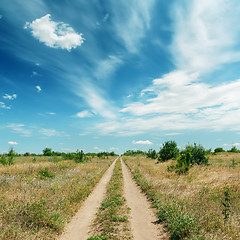 Image showing rural road in green landscape and dramatic blue sky with clouds