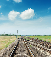 Image showing crossing of two railroads and blue sky with clouds