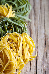 Image showing yellow and green uncooked pasta tagliatelle 