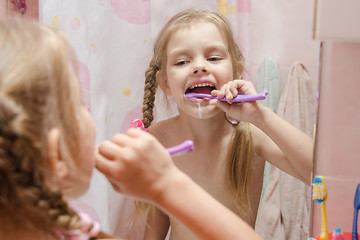 Image showing Five-year girl brushing her teeth in bathroom