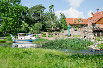 Image showing cruise wherry moored at pier near ancient manor  