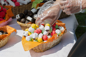 Image showing hand takes baked pastry mushrooms from basket 