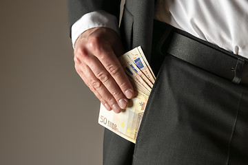 Image showing Businessman putting money in pocket