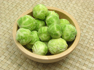 Image showing Wooden bowl with brussels sprouts on rattan underlay